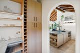 Kitchen, Vessel Sink, Accent Lighting, Track Lighting, Microwave, Wood Cabinet, Vinyl Floor, Dishwasher, and Stone Counter Pantry with adjustable wine rack with option for storing vertical items like cutting boards  Photo 8 of 18 in Casa Serena by The Nature Studio