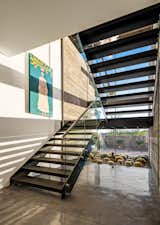 Staircase, Metal Tread, Metal Railing, Concrete Tread, and Glass Railing First story stair hall view with planter mirroring exterior landscaping.  Photo 3 of 15 in Big Girl House by Tate Studio Architects