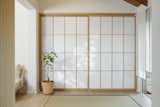 Shoji  door made of solid wood filled with plexiglass panels in the foyer where tatami mattresses are integrated
