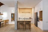 Kitchen island made of oak veneer facing the public space and the dining area