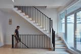 A modestly refinished staircase with black railing and accent light