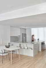Kitchen, Light Hardwood Floor, White Cabinet, Marble Counter, Stone Counter, Refrigerator, Engineered Quartz Counter, Undermount Sink, Laminate Cabinet, Quartzite Counter, Stone Slab Backsplashe, and Recessed Lighting A minimalist chef's kitchen made to endure heavy cooking  Photo 4 of 12 in Bay Street Townhouse by Architecture Riot