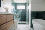 Bath Room, Freestanding Tub, Engineered Quartz Counter, Wall Lighting, Terrazzo Floor, Porcelain Tile Wall, Enclosed Shower, Two Piece Toilet, and Undermount Sink  Photo 13 of 13 in Clean lines with a retro spin by Jill Lamphier