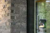 An exterior corner showcases the dry-stack natural stone veneer in 2" tall Pacific Ashlar, emphasizing texture, craft, and the home’s connection to its regional materials.