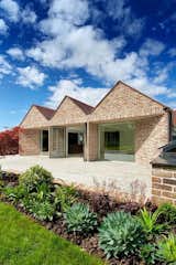 Roof Architecture: Featuring a triple-gabled design, the garden elevation of the new build house incorporates living space on the first floor, creating a direct connection from the interior to the inviting South-facing patio
