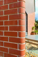 Bullnose bricks serve as an architectural bridge between eras by referencing the original brick and render finish of the 1930s house.