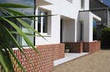 The brick plinth detail introduces a sense of height to the expansive front elevation through the strategic vertical alignment of bricks. An array of textures, carefully curated, enhances the visual interest with a touch of architectural sophistication.