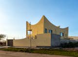 Exterior, Concrete Siding Material, House Building Type, Curved RoofLine, and Tile Roof Material Backside of the house with the "great wave" of the roof  Photo 5 of 7 in The Wave House of Hargeisa by omar degan