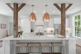 Chef's kitchen features copper light fixtures, quarts countertops, a designer backsplash and induction range