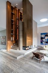 To enhance the double-height space, a central statement element was designed that combines the functions of stairs, library and fireplace.