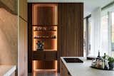 Indirect lighting highlights the cabinetry in slatted walnut.
