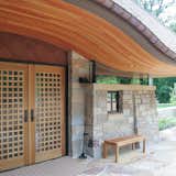 Front entry with gridded wood doors and flowing arched wood ceiling