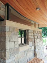 Exterior, Stone Siding Material, Curved RoofLine, House Building Type, Shingles Roof Material, Glass Siding Material, Metal Siding Material, and Wood Siding Material Window detail at stone wall  Photo 14 of 38 in Copper Fish Scale Home by Bjella Architecture