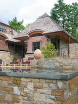 Exterior, Curved RoofLine, Wood Siding Material, Hipped RoofLine, Stone Siding Material, Shingles Roof Material, House Building Type, Metal Siding Material, and Glass Siding Material Infinity edge pool detail  Photo 16 of 38 in Copper Fish Scale Home by Bjella Architecture