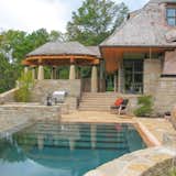 Exterior, Stone Siding Material, Shingles Roof Material, Glass Siding Material, Curved RoofLine, Metal Siding Material, House Building Type, Wood Siding Material, and Hipped RoofLine View of outdoor dining pavilion from pool  Photo 17 of 38 in Copper Fish Scale Home by Bjella Architecture