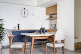 Dining nook, homeowner's favorite spot to unwind and foster conversations while sitting comfortably in custom dining chairs with an offbeat arm rest that complement the terrazzo-topped dining table. An electric blue crockery cabinet adds an element of surprise
