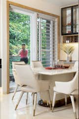 A connected balcony adds a delightful touch, offering picturesque views of lush greenery. This integration transforms the compact space into a perfect haven. Marked by a keen eye for detail and a subtle grey and white palette, the design achieves a harmonious balance between aesthetics and functionality. Meticulously arranged elements create an inviting atmosphere, establishing this zone as an ideal hub for culinary pursuits and shared meals.