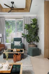 Platinum disc-colored walls serve as a refined backdrop, and the rust orange and muted green seating, paired with a hint of vanilla-dyed veneer, seamlessly infuse the space with warmth and serenity, cultivating a harmonious and inviting atmosphere. 