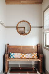 I painted the wood floors that were in bad shape, vaulted the ceiling, and covered it with new white oak. I added an antique chandelier and pew and vintage mirror for coming and going. Peg rails throughout the house help with storage in the small space.