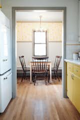 The dining space has a built in bench, antique chandelier that matches the entry, and estate and thrifted furnishings. 