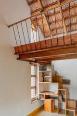 mezzanine floor made of wood provides an elevated space for reading or relaxation , optimizing the use of vertical space 