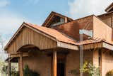 Exposed brick facade with  customized rainwater duct   Photo 1 of 29 in Brick Manor by Bhutha Earthen Architecture Studio 