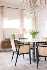 The formal Dining room. Painted in Sherwin Williams "Intimate White" to give the room a soft pink feel. The chandelier was sourced from Anthropologie and through-out the room are a mixture of new and vintage pieces like the solid crystal lamp with vintage shade on the midcentury-modern credenza.