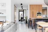 Kitchen, Wood Cabinet, Wall Oven, Ceiling Lighting, Marble Counter, Concrete Floor, Refrigerator, Pendant Lighting, and Marble Backsplashe Living/Kitchen  Photo 6 of 10 in McNeill House by ARYZE Developments Inc.