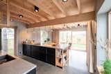 Kitchen, Ceiling Lighting, Pendant Lighting, Open Cabinet, Wood Cabinet, Cooktops, Undermount Sink, Track Lighting, Stone Counter, and Concrete Floor The ceiling and windows in pine adds warmth to the concrete.   Photo 8 of 12 in Villa Kummelnäs by Sigrid Svensson