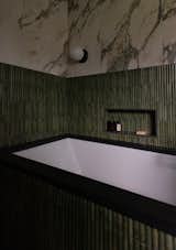 Design-build bathroom tub view with wet rated sconce