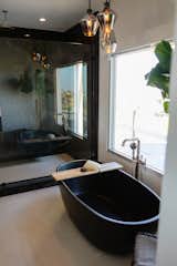 Black bathtub and Brizo plumbing fixtures.