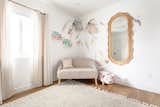 Kids Room, Girl Gender, Bedroom Room Type, Chair, Toddler Age, Rug Floor, Vinyl Floor, and Bench Girl’s room featuring Urban Outfitters rattan mirror and urban walls wall decals  Photo 7 of 23 in Pacific Beach House by Belyn Studio
