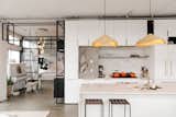 Kitchen, Engineered Quartz Counter, Refrigerator, Undermount Sink, Range, Concrete Floor, Open Cabinet, Pendant Lighting, Cooktops, White Cabinet, and Dishwasher Chef's kitchen  Photo 9 of 15 in The Artists' Penthouse by Molly Lowe