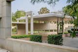 A linear wall, punctuated with strategic openings, shields the garden from view