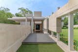The design incorporates bold, unadorned materials like concrete and sandstone