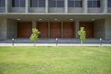 The verdant front lawn provides a soft touch to the raw monumentality of the built form