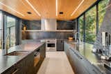 Kitchen, Marble Counter, Ceiling Lighting, Range Hood, Concrete Floor, and Range A modern kitchen features locally sourced Vancouver Island marble countertops and FSC marine grade plywood.  Photo 1 of 821 in A frame house ideas by kirstie from Alpine A-Frame