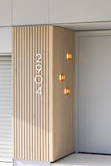 Dimple flush mounted sconces superimposed on grey washed cedar lights up the front entrance.
