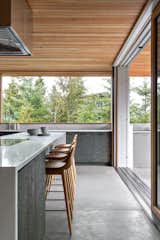 The kitchen island, backsplash, and perimeter countertops, all Vancouver Island White Marble, make a bright clean contrast against the darker cabinets.