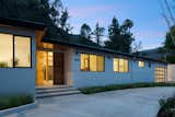 Exterior, Stucco Siding Material, House Building Type, Shingles Roof Material, Gable RoofLine, and Mid-Century Building Type Front Entrance at Night  Photo 2 of 15 in Mandeville Canyon - Mid Century Modern Revamp by Mark Nichols - MNichols Design