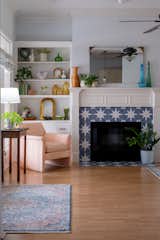 Living Room, Medium Hardwood Floor, Chair, Light Hardwood Floor, Console Tables, Rug Floor, Lamps, Shelves, Standard Layout Fireplace, and Cement Tile Floor  Photo 4 of 7 in Midcentury Flair takes on Small Town Texas by Aften Lane