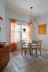 Dining Room, Table, Chair, Accent Lighting, Storage, Ceramic Tile Floor, Rug Floor, and Pendant Lighting  Photo 5 of 7 in Midcentury Flair takes on Small Town Texas by Aften Lane