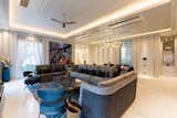 The living area is dressed in white hues while a blue and grey sofa juxtaposes the space and serves as a focal point in the area.