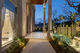 Located in an urban locality, the residence evokes a fusion of classical design with contemporary aesthetics. This is reflected in the design of the facade mimicking the essence of classical architecture with arched windows and Corinthian columns. Sleek lines and trabeated cornices define the style, adding a vintage look to the facade.
