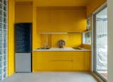 Kitchen, Ceiling Lighting, Range Hood, Glass Tile Backsplashe, Cooktops, Stone Counter, Refrigerator, Colorful Cabinet, and Drop In Sink  Photo 7 of 12 in A Minimalist- Postmodern Condo Room by Mae Prachasilchai