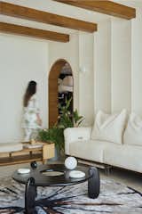 A spacious living room adorned with earthy tones, a plush sofa, and a vibrant touch of greenery.