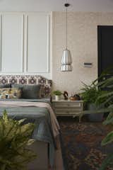 The master bedroom is adorned with rich textures and colorful patterns, offering a warm welcome with its eclectic charm.