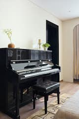 A sleek black piano stands as a centerpiece, surrounded by subtle decor elements that harmonize sophistication with a personal touch.