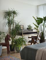 A cozy office space that doubles as a sanctuary, filled with lush plants and earthy tones, inviting inspiration amidst urban jungle vibes.
