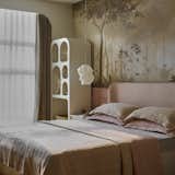 A dreamscape comes alive in this  bedroom, where hand-painted murals create a whimsical backdrop.